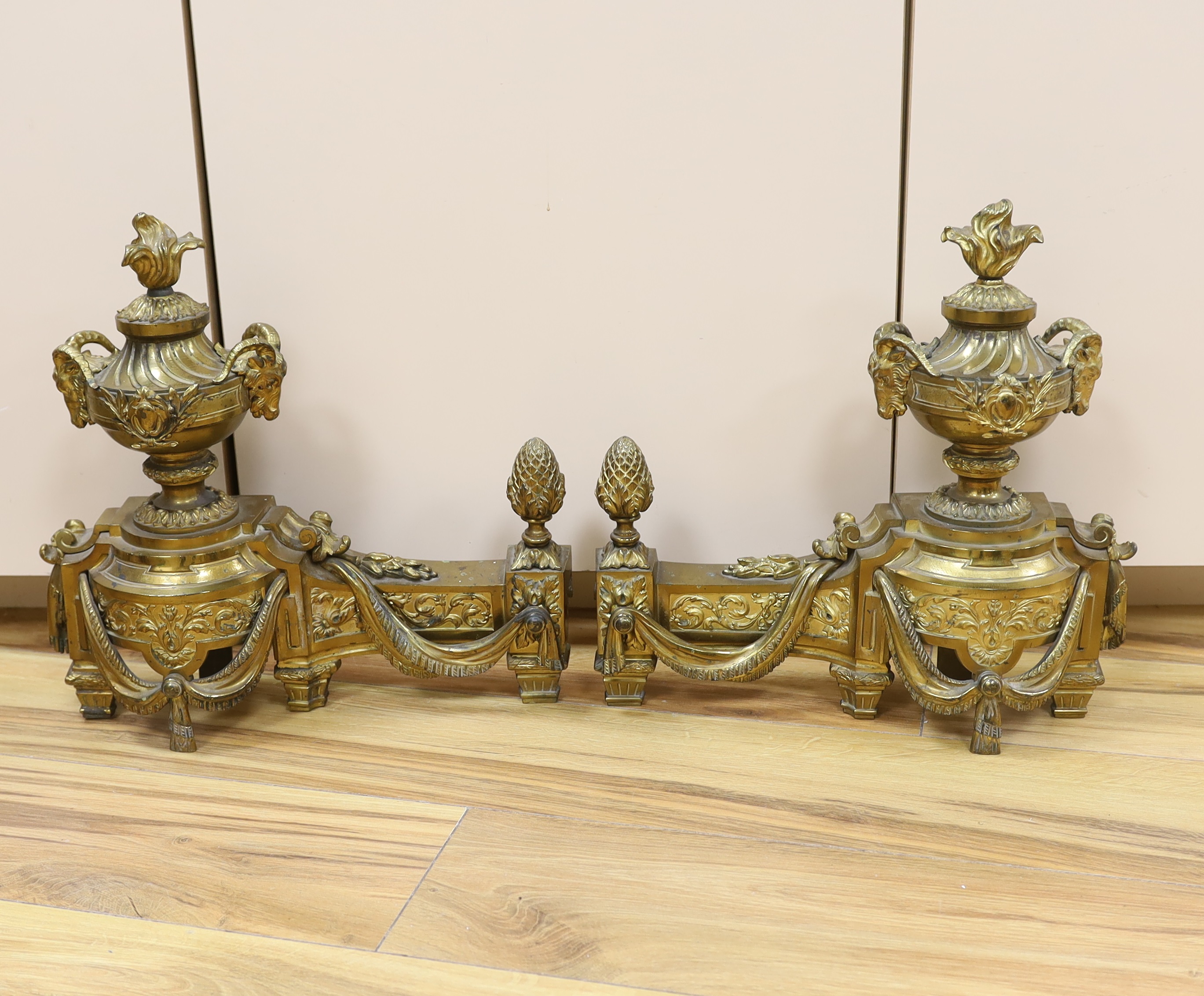 A French gilt bronze pair of urn shaped chenet, 39cm wide